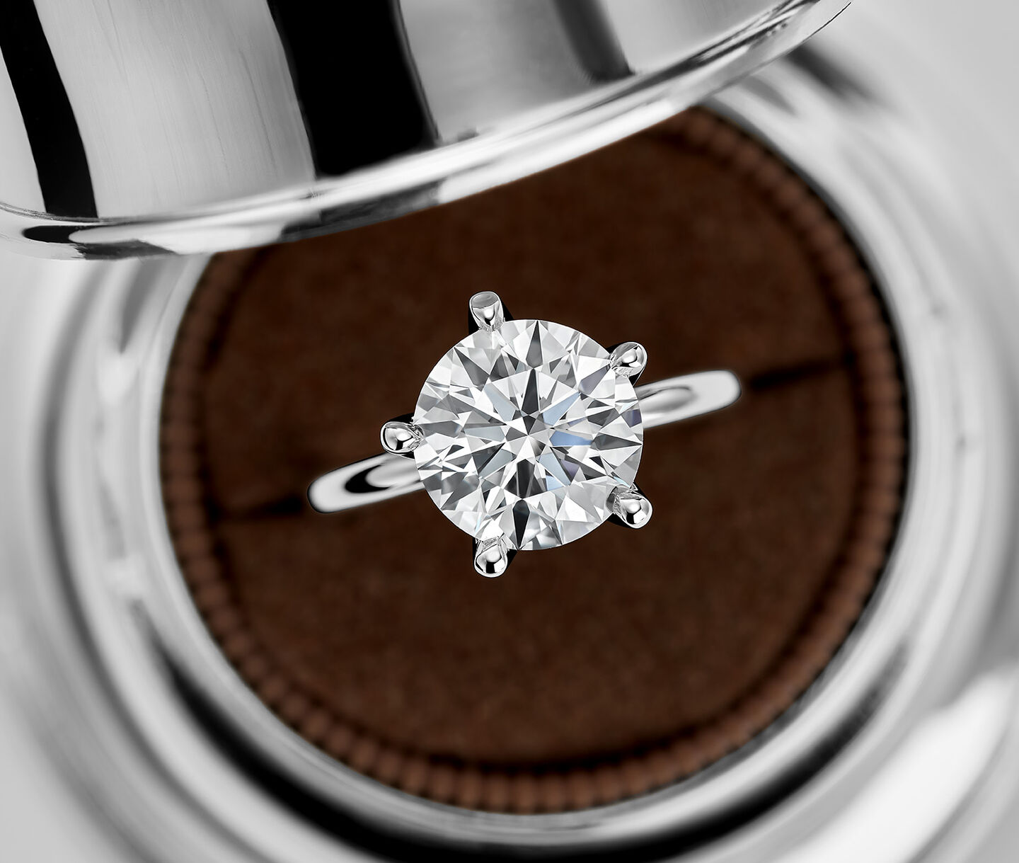 A Birks Bell Box holding a Birks North Star Round Diamond Solitaire Engagement Ring.